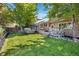 Spacious backyard features a well-maintained lawn, deck with outdoor dining, and a relaxing hot tub at 9606 Whitecliff Pl, Highlands Ranch, CO 80129