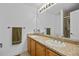 Bathroom featuring double sinks with wooden cabinets, neutral countertops, and a large mirror at 9606 Whitecliff Pl, Highlands Ranch, CO 80129