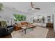 Spacious living room with hardwood floors, lots of seating, and an open view to the kitchen at 9606 Whitecliff Pl, Highlands Ranch, CO 80129