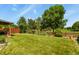 Well-maintained backyard featuring a lush lawn, mature trees, and a charming wooden fence at 13235 Clermont Cir, Thornton, CO 80241