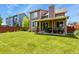 Expansive backyard featuring lush green grass, a covered patio with seating, and a privacy fence at 13235 Clermont Cir, Thornton, CO 80241