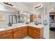 Bathroom vanity with double sinks, wood cabinets, and large mirror, offering a bright and functional space at 13235 Clermont Cir, Thornton, CO 80241