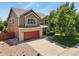 Charming two-story home featuring a red garage door, brick accents, and a well-manicured lawn at 13235 Clermont Cir, Thornton, CO 80241