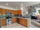 Open kitchen boasts stainless appliances, tile backsplash, wood cabinets, and seamless flow to the living space at 13235 Clermont Cir, Thornton, CO 80241