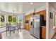Bright eat-in kitchen with wood cabinets, stainless steel fridge, and a view of the backyard at 13235 Clermont Cir, Thornton, CO 80241