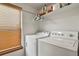 Bright laundry room with modern washer and dryer units, shelf storage and natural light at 13235 Clermont Cir, Thornton, CO 80241