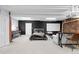 A spacious basement bedroom with exposed brick, comfortable furnishings, and a large screen for entertainment at 2560 Blake # 101, Denver, CO 80205