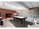 Basement recreation area with a pool table, flat screen TV, and exposed brick wall at 2560 Blake # 101, Denver, CO 80205