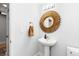 Bathroom featuring a modern pedestal sink with a decorative gold mirror and fixtures, and white wall paint at 2560 Blake # 101, Denver, CO 80205