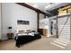Spacious bedroom with exposed wood beams, high ceilings, and sliding barn door to a walk-in closet at 2560 Blake # 101, Denver, CO 80205