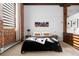 Bedroom featuring exposed brick, a city skyline picture, and a comfortable bed with stylish bedside tables at 2560 Blake # 101, Denver, CO 80205
