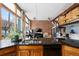 Stylish kitchen featuring dark granite countertops, wood cabinets, and an open concept living space with exposed brick at 2560 Blake # 101, Denver, CO 80205