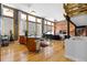 Open living space featuring hardwood floors, exposed brick wall, and a piano at 2560 Blake # 101, Denver, CO 80205
