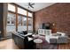 Stylish living room featuring large windows, exposed brick wall, and comfortable seating with city views at 2560 Blake # 101, Denver, CO 80205
