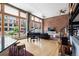 Bright living room with floor to ceiling windows, hardwood floors, and exposed brick at 2560 Blake # 101, Denver, CO 80205