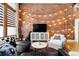 Charming living room with exposed brick wall, string lights, and a cozy seating arrangement at 2560 Blake # 101, Denver, CO 80205