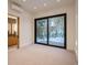 Bright, carpeted bedroom with a sliding glass door looking out on snow covered pines at 27 Boulder Cir, Breckenridge, CO 80424