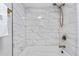 Stylish bathroom featuring a tub with elegant marble-look tiling and gold fixtures at 701 Harlan St # E53, Lakewood, CO 80214