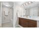 Bright bathroom with dual sinks, modern wood vanity, and updated tile flooring at 701 Harlan St # E53, Lakewood, CO 80214