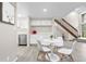 Bright dining area features white table and chairs, with nearby kitchenette and access to staircase at 701 Harlan St # E53, Lakewood, CO 80214