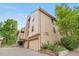 Exterior view of a multi-story townhome with attached garages and landscaped front yard at 701 Harlan St # E53, Lakewood, CO 80214