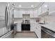 The kitchen features stainless steel appliances, sleek countertops, and white cabinets with gold hardware at 701 Harlan St # E53, Lakewood, CO 80214