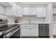 A close-up of the kitchen sink and stovetop showcases the updated white cabinets and stainless appliances at 701 Harlan St # E53, Lakewood, CO 80214