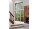 Living room with staircase, large windows, view to green trees, and wooden fireplace at 701 Harlan St # E53, Lakewood, CO 80214