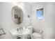 Bright half-bathroom with pedestal sink and oval mirror, offering classic charm and functionality at 20 W Ranch Trl, Morrison, CO 80465