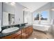 Bright bathroom featuring double sinks, a clawfoot tub, and a window with an attractive outdoor view at 20 W Ranch Trl, Morrison, CO 80465