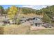 Charming home exterior with a stone patio, pergola, and lush trees at 20 W Ranch Trl, Morrison, CO 80465