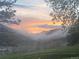 Stunning sunset view over misty mountains and lush, green hillside at 20 W Ranch Trl, Morrison, CO 80465