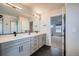 Modern bathroom with double sinks, gray cabinets, large mirror, and walk-in shower at 16881 Roaming Elk Dr, Monument, CO 80132