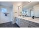 Modern bathroom featuring double sinks, gray cabinets, and a large mirror at 16881 Roaming Elk Dr, Monument, CO 80132
