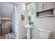 Stylish powder room with pedestal sink, decorative mirror, and patterned tile flooring at 16881 Roaming Elk Dr, Monument, CO 80132