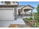 Inviting home with a covered porch, showcasing landscaped front yard and stone exterior accents at 16881 Roaming Elk Dr, Monument, CO 80132