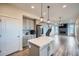 Bright, modern kitchen with island, stainless appliances, gray cabinets, and hardwood floors at 16881 Roaming Elk Dr, Monument, CO 80132