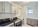Functional laundry room features modern washer and dryer units, cabinetry, and utility sink at 16881 Roaming Elk Dr, Monument, CO 80132