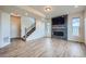 Bright living room featuring a fireplace, TV, neutral walls, and beautiful laminate floors at 16881 Roaming Elk Dr, Monument, CO 80132