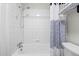 Clean bathroom with a tiled tub and shower, and white and blue striped shower curtain at 2616 Utica St, Denver, CO 80212