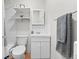 Functional bathroom featuring a toilet, sink with vanity, and white tiled walls at 2616 Utica St, Denver, CO 80212