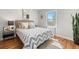Inviting bedroom with a zigzag-patterned bedspread, bedside table, and natural light from a window at 2616 Utica St, Denver, CO 80212