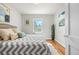 Bright bedroom with a zigzag-patterned bedspread, hardwood floors, and natural light from a window at 2616 Utica St, Denver, CO 80212