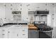 Well-maintained kitchen featuring white cabinetry, black countertops, stainless steel appliances, and ample storage at 2616 Utica St, Denver, CO 80212