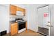 Kitchen with wood cabinets, gas range, microwave, and exterior access at 403 W 3Rd Ave, Denver, CO 80223