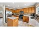 Traditional kitchen features stainless steel appliances, tile floors, and light wood cabinets at 12850 Ventana St, Parker, CO 80134