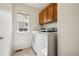 Bright laundry room features updated appliances and convenient overhead cabinets for easy storage solutions at 12850 Ventana St, Parker, CO 80134