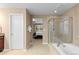 Bright bathroom featuring a glass-enclosed shower, soaking tub, and neutral tile at 14278 Greenfield Loop, Parker, CO 80134
