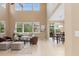Bright and airy living room with high ceilings, large windows, and an adjacent dining area at 14278 Greenfield Loop, Parker, CO 80134