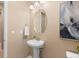 Charming powder room with a pedestal sink, decorative mirror, and neutral color scheme at 14278 Greenfield Loop, Parker, CO 80134
